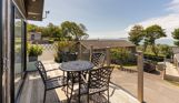External of a lodge decking with outdoor furniture and sea views