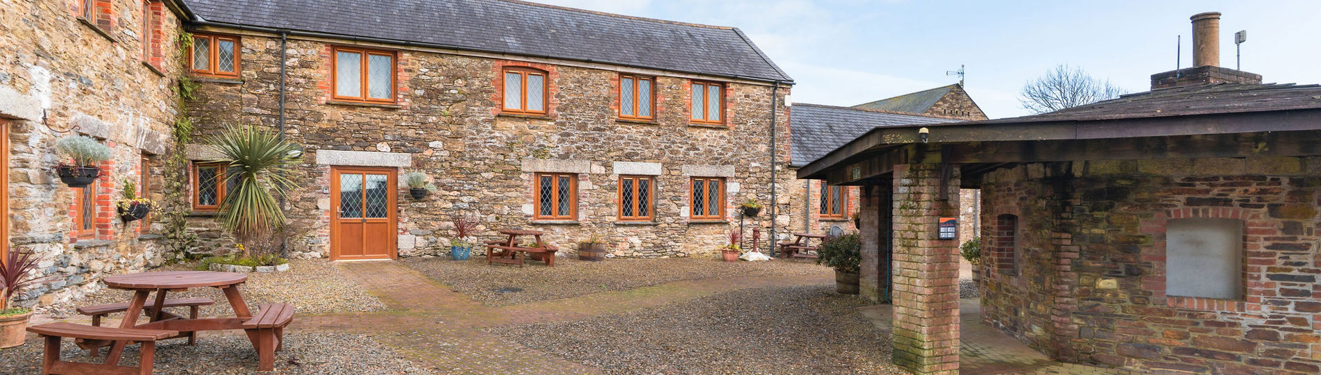 External of a cottage courtyard area with outdoor benches and flowers