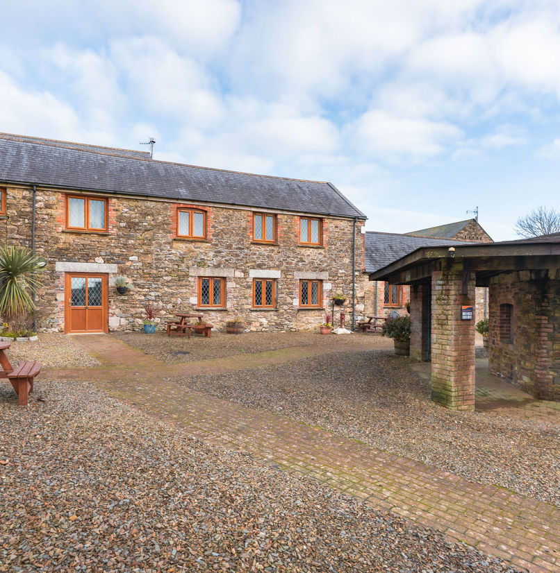 External of a cottage courtyard area with outdoor benches and flowers
