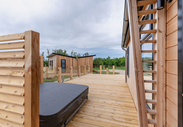 External of a luxury lodge on pitch with decking and hot tub