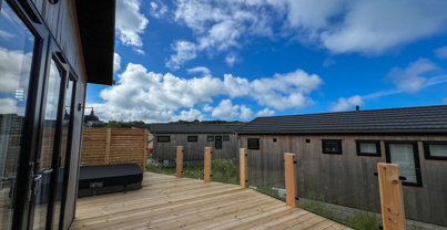 External of a luxury lodge on pitch with decking and hot tub