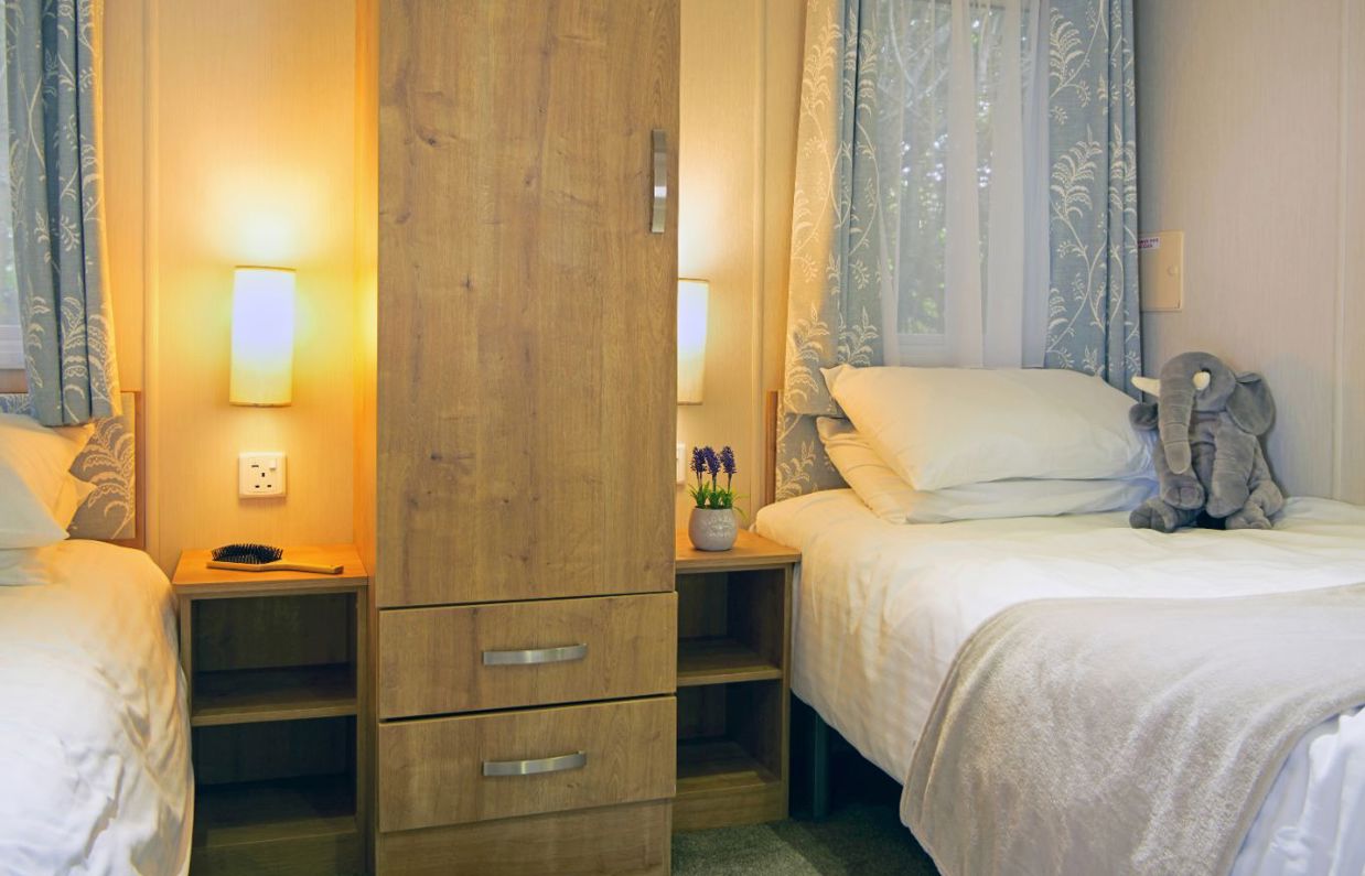 Internal of an accessible caravan spacious twin bedroom with storage