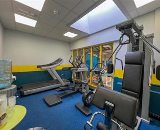 An indoor gym with various cardio and weight lifting equipment 