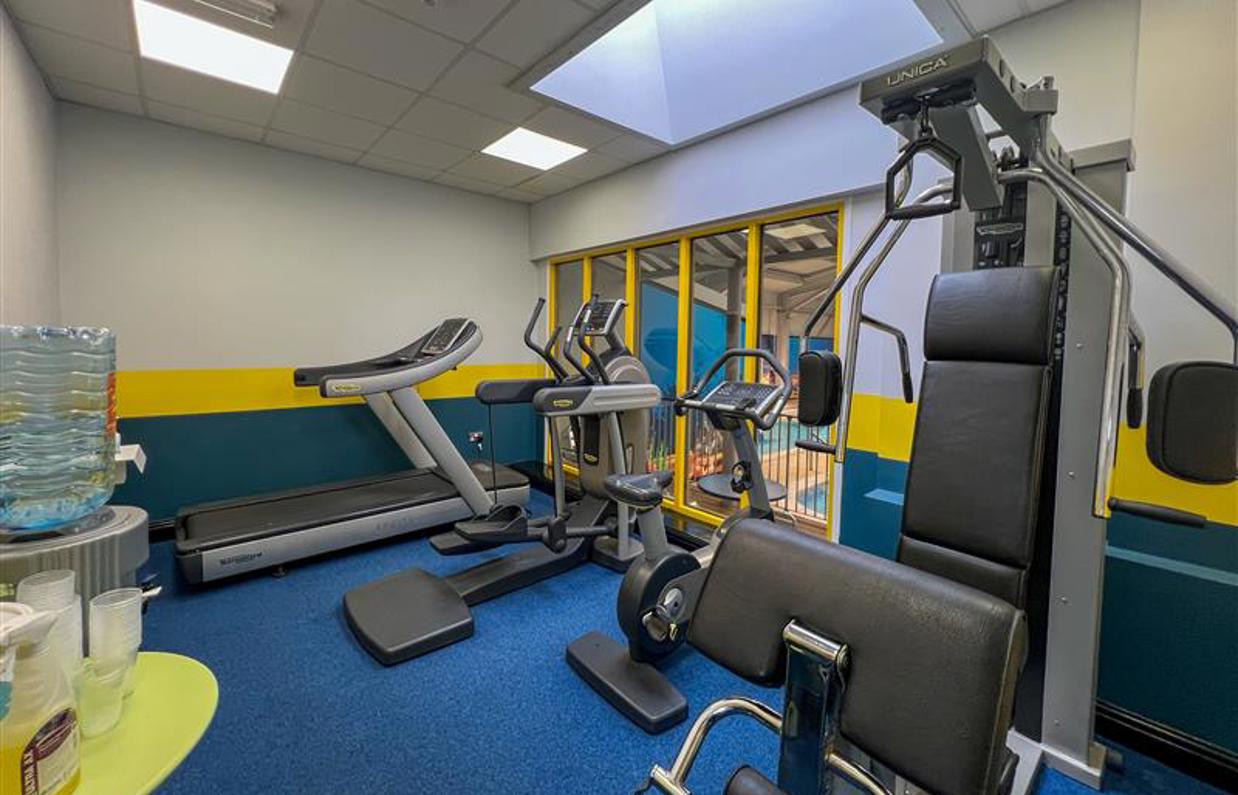 An indoor gym with various cardio and weight lifting equipment 