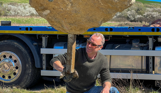 Installation of a stone sculpture in a field with blue skies