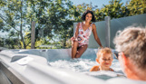 Family in hot tub surrounded by trees