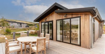 External of a luxury lodge with decking and outdoor furniture