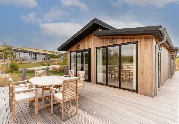 External of a luxury lodge with decking and outdoor furniture