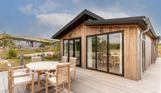 External of a luxury lodge with decking and outdoor furniture