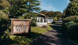 Cedar Falls entrance sign on Osmington Mills Lodge Park surrounded by lodges and woodland