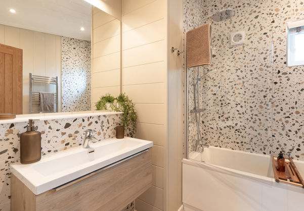 Internal of a luxury lodge bathroom with sink and shower over bath
