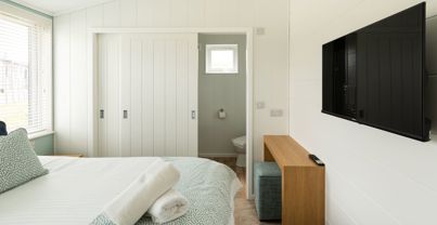 Internal of a luxury lodge master bedroom with ensuite and storage