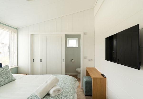 Internal of a luxury lodge master bedroom with ensuite and storage