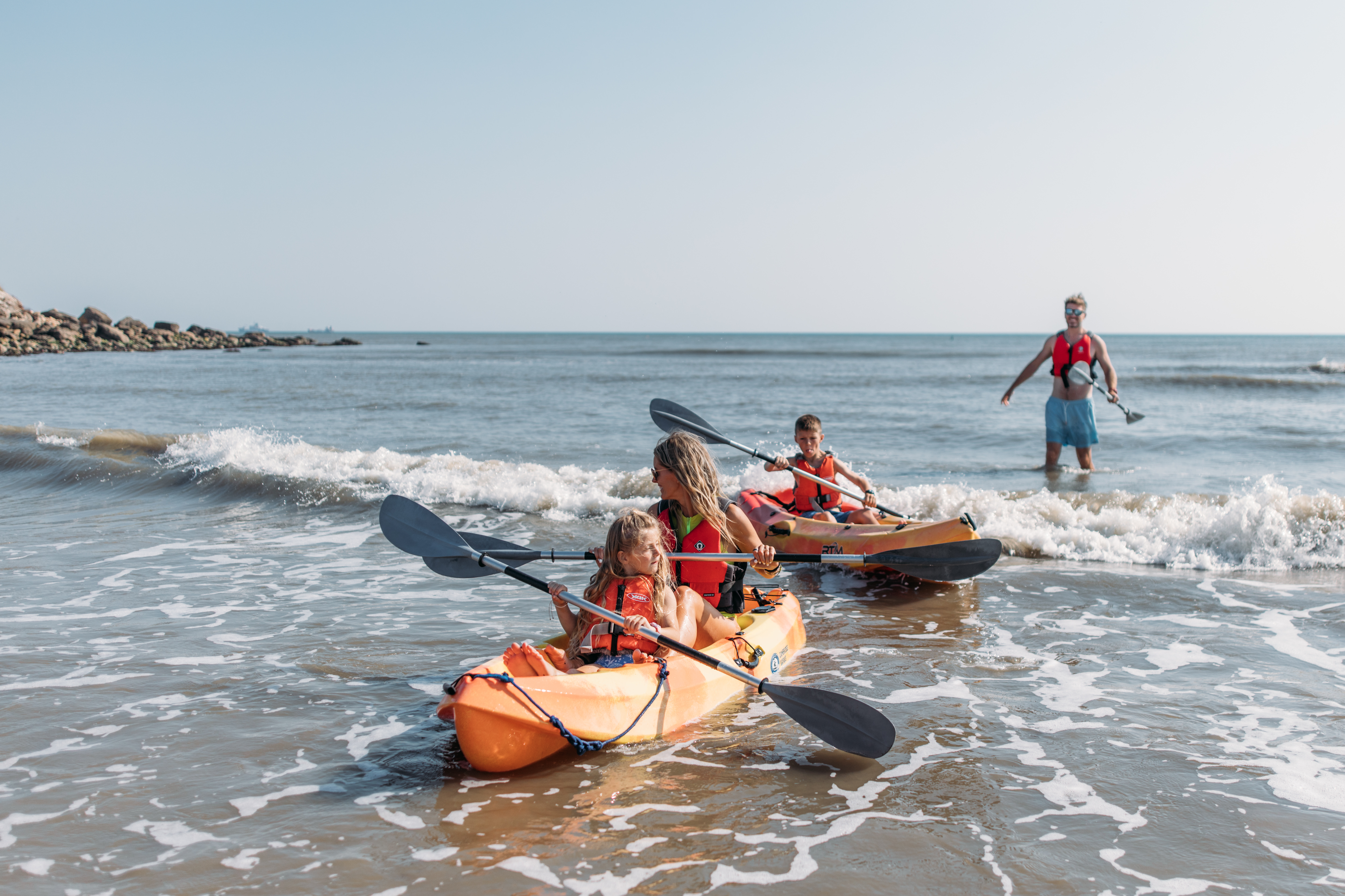 A family of four kayaking in the sea