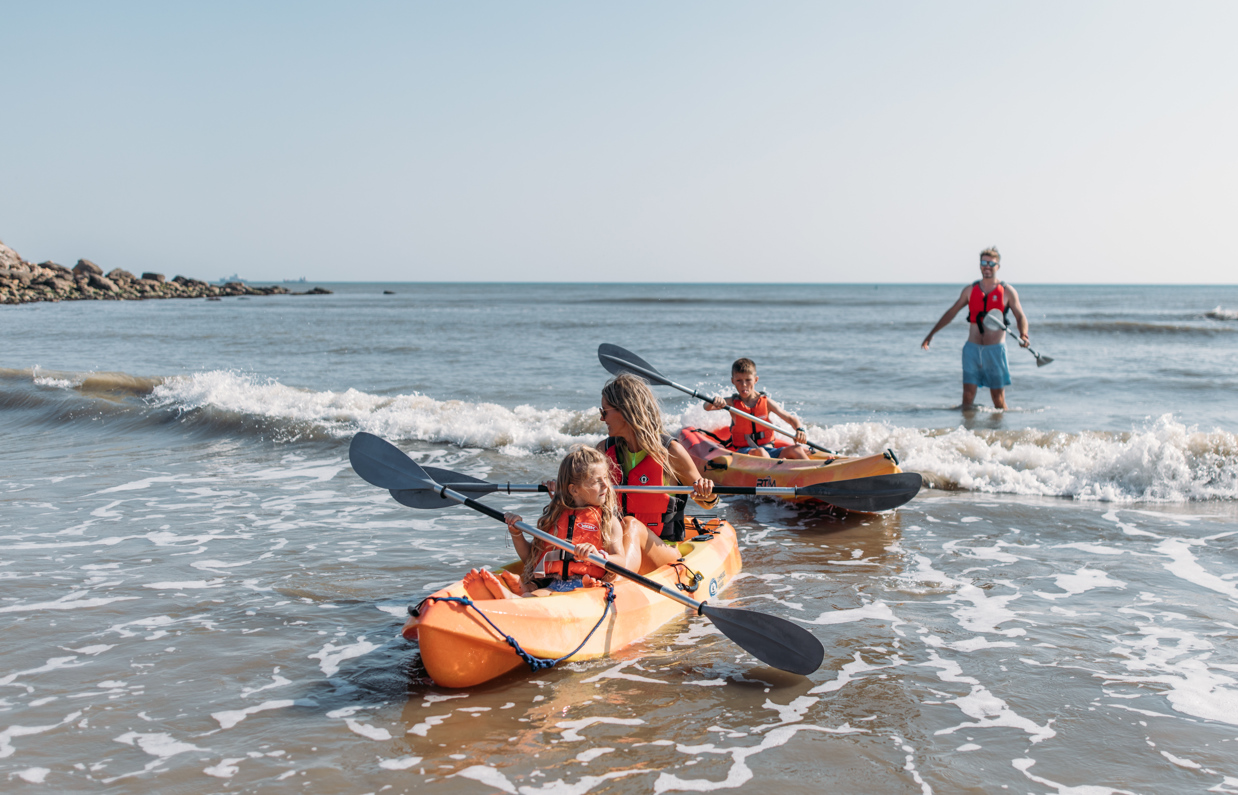 A family of four kayaking in the sea