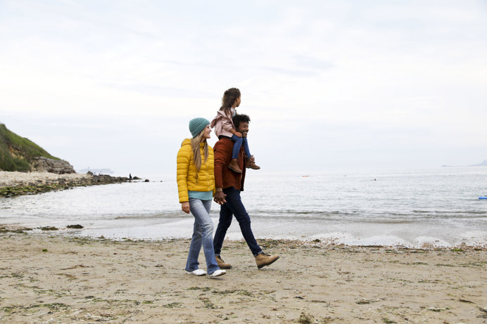 Family walking on beach in autumn