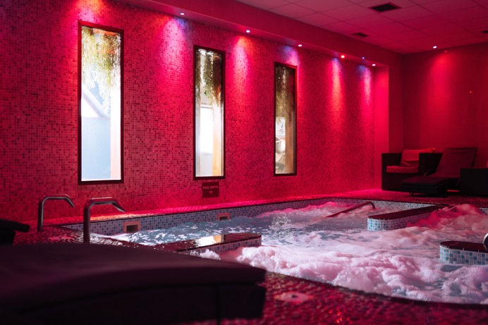 A hydrotherapy pool with loungers and calm lights