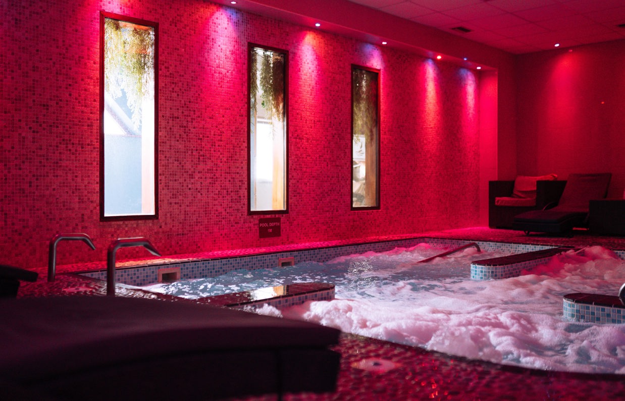 A hydrotherapy pool with loungers and calm lights