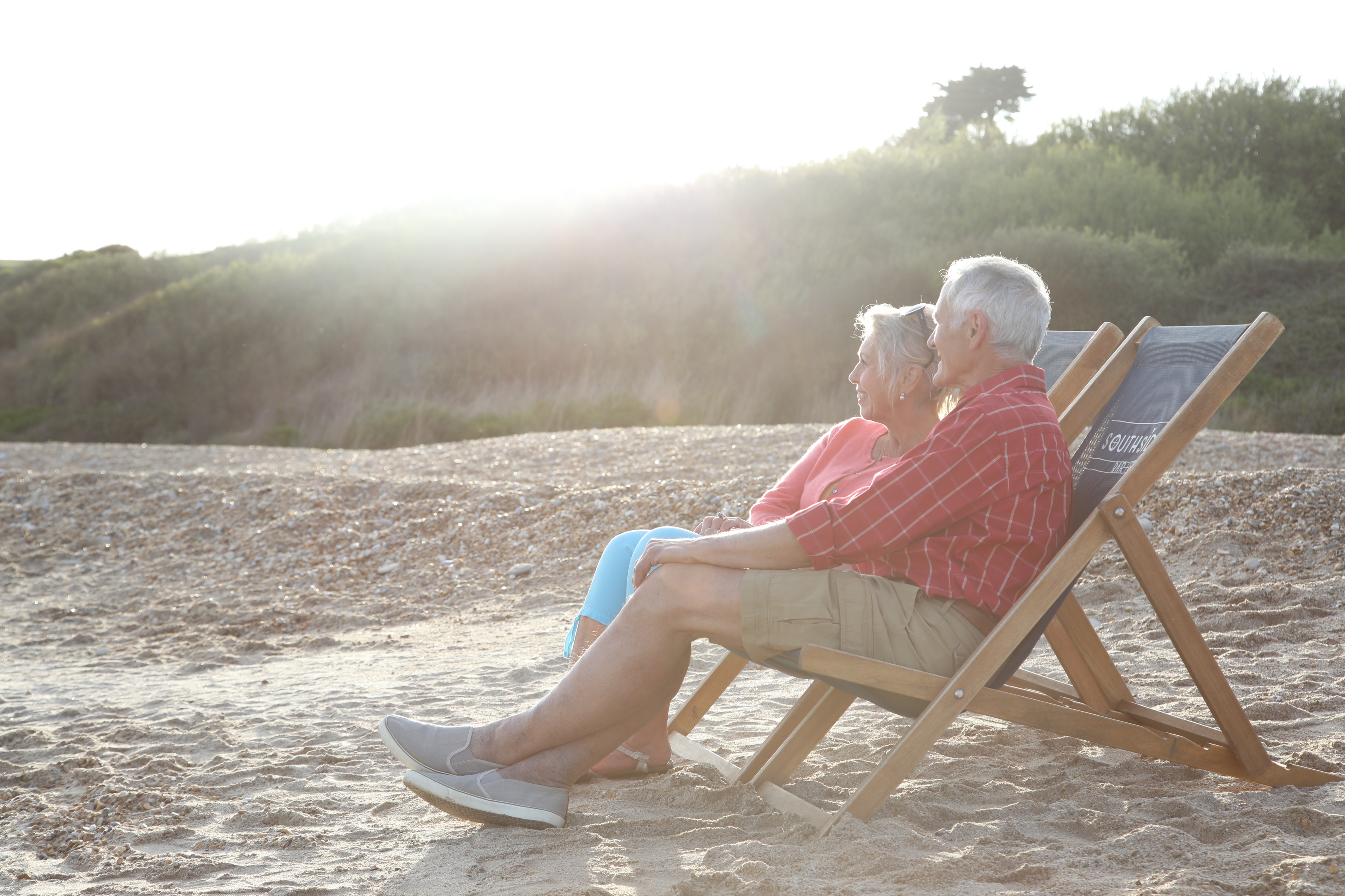 Older couple relax on deckchairs on  Weymouth Beach