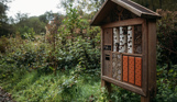 A wooden bug hotel with different sections among woodland