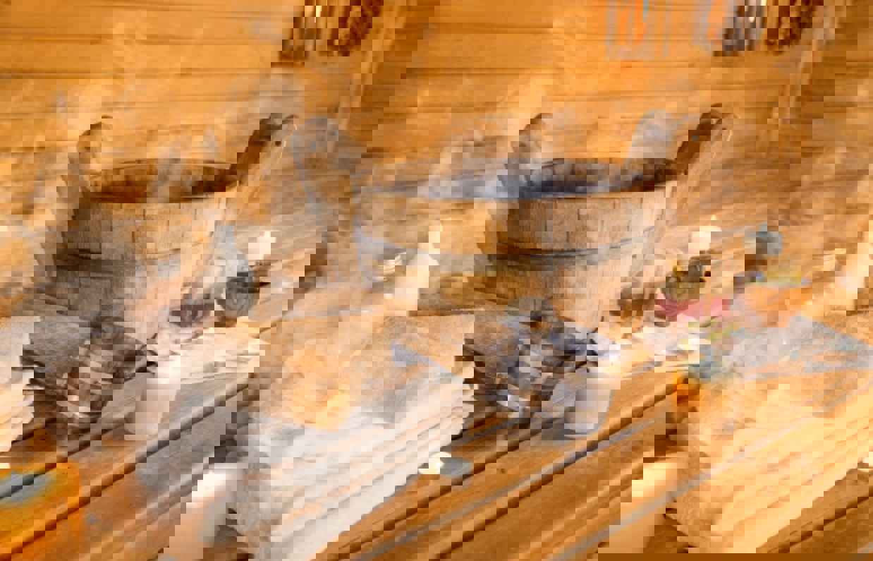 The inside of a sauna with towels, products, steam and tea lights