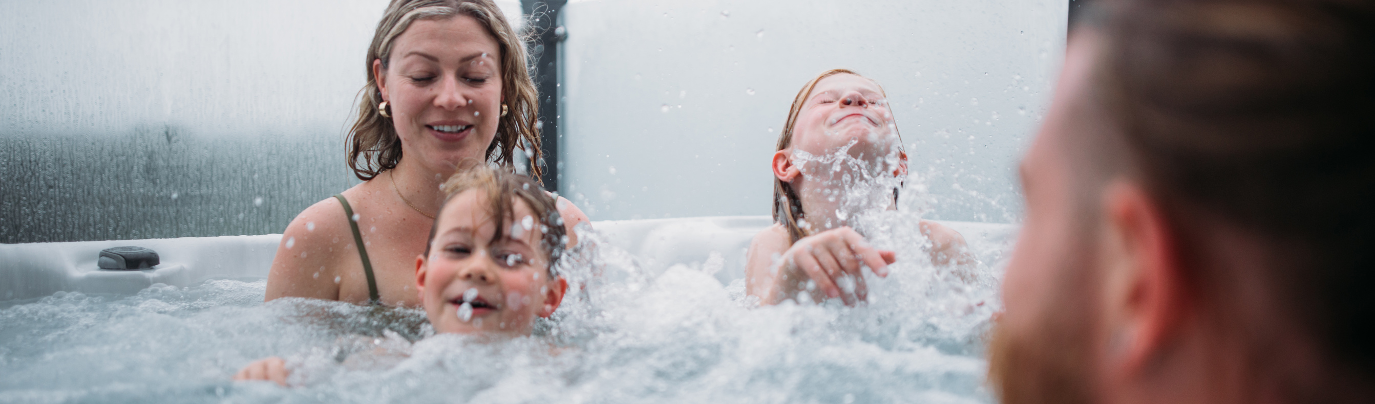 Family enjoying hot tub at holiday home in Tregoad