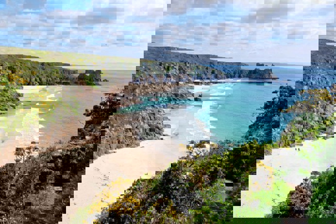 A sandy beach at low tide with blue waters
