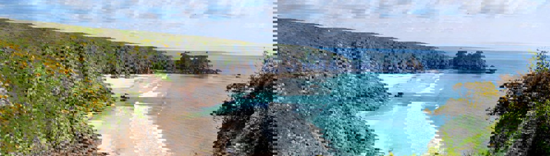 A sandy beach at low tide with blue waters