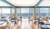 Striking sea views from the inside of Drift Bar & Grill seating area on a sunny, blue sky day