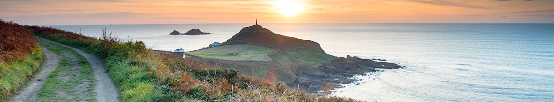 A coastal path with views of the sea and sunset