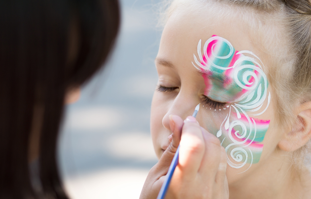A young girl having her face painted