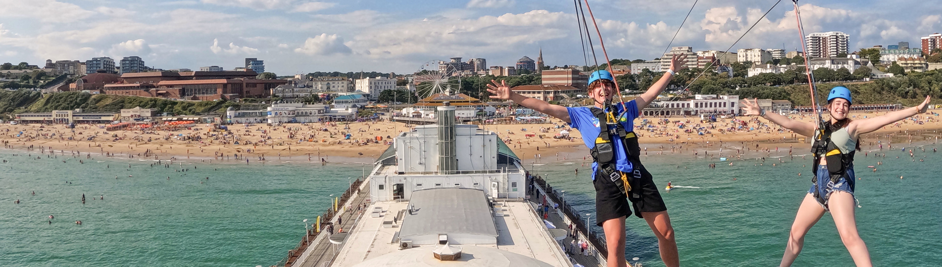Two people on a zip line over Bournemouth Pier