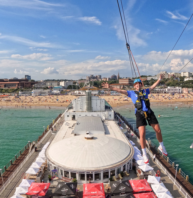 Two people on a zip line over Bournemouth Pier