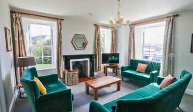 Internal of a manor house lounge with sofas and a tv