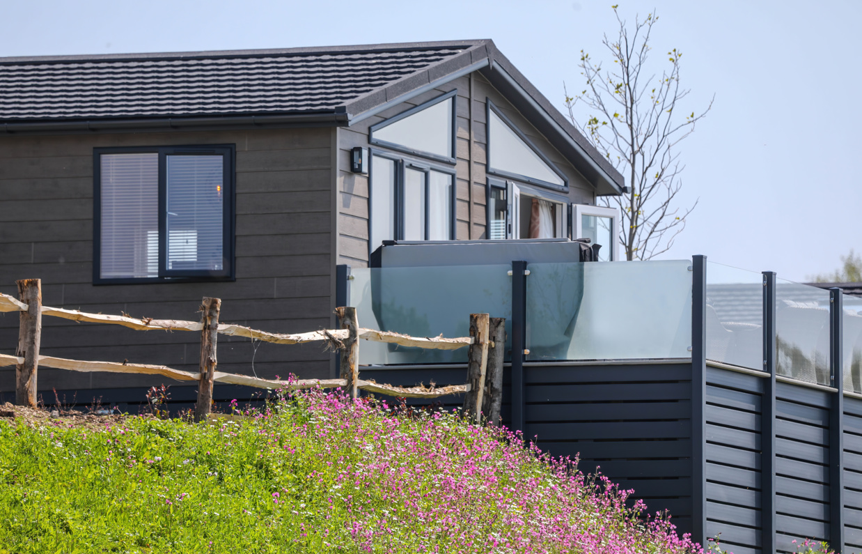 A luxury lodge with decking on Samphire Cove at Tregoad Holiday Park