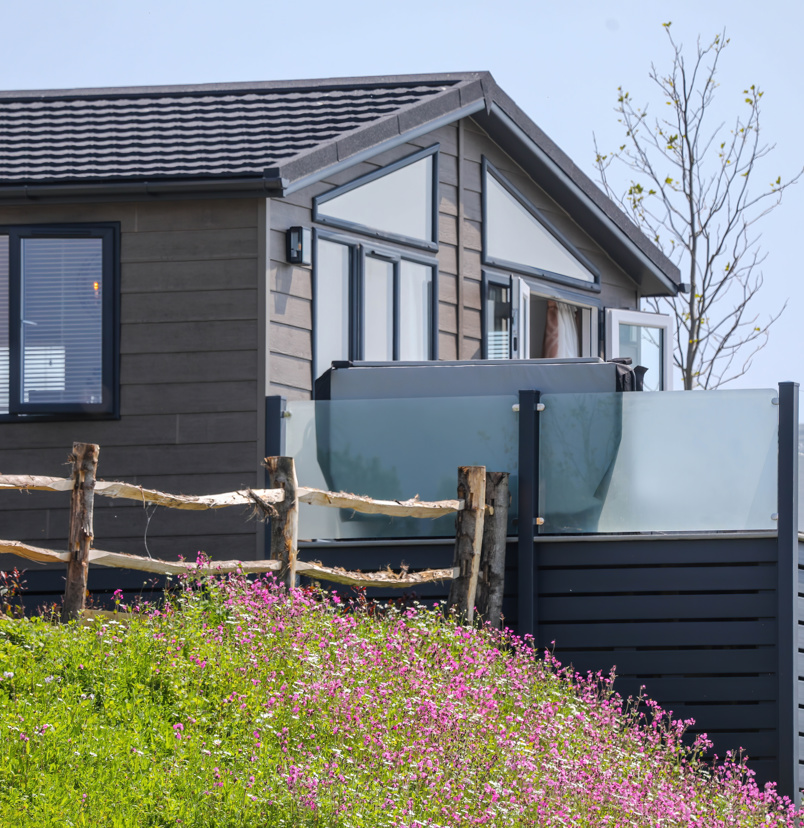A luxury lodge with decking on Samphire Cove at Tregoad Holiday Park