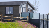 A luxury lodge with decking on Samphire Cove at Tregoad Holiday Park