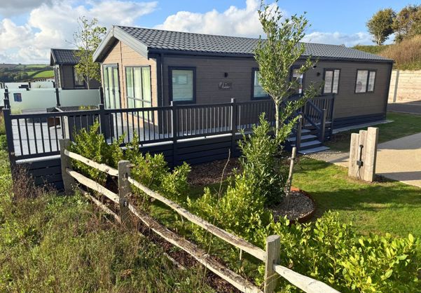 External of a luxury lodge on pitch with decking and hot tub