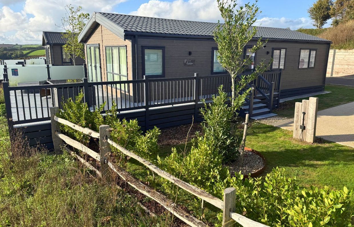 External of a luxury lodge on pitch with decking and hot tub