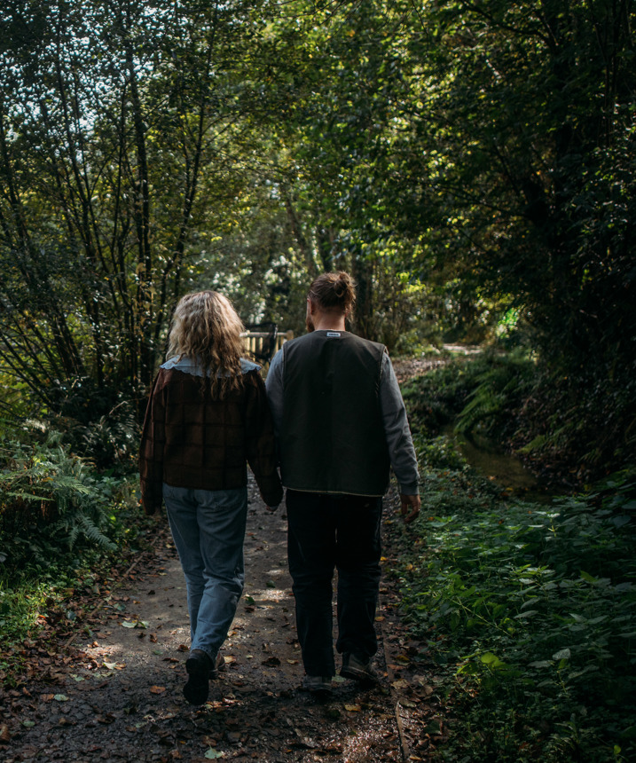 Couple walking though woodland alongside lakes at Tregoad