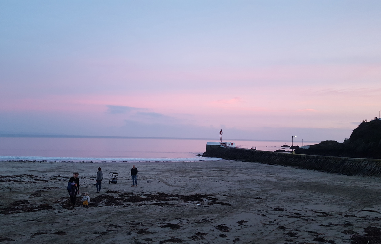 The view of Banjo Pier from Looe Beach at sunset with pink skies