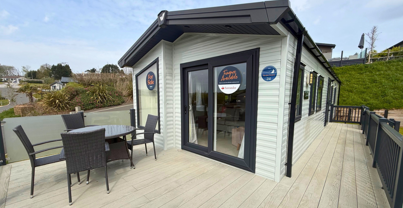 External of a caravan on pitch with decking and table and chairs