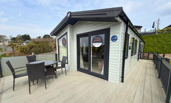 External of a caravan on pitch with decking and table and chairs