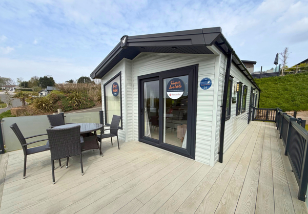 External of a caravan on pitch with decking and table and chairs