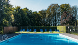 An outdoor pool with a sun terrace and sun loungers on a sunny day