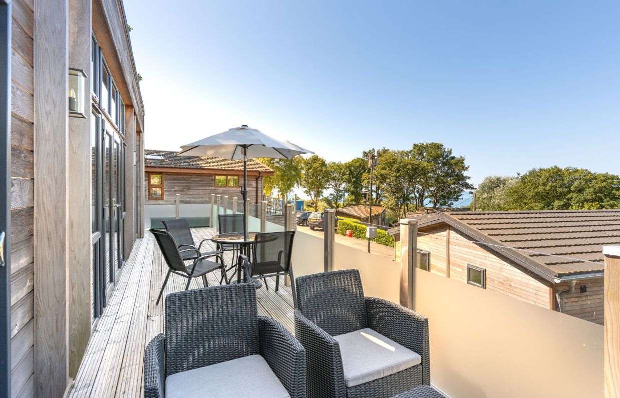 External of a lodge decking with outdoor furniture and sea views