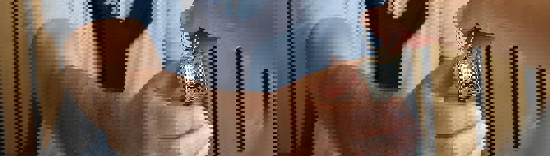 A woman's hand passing a set of keys to a man whose hand is stretched out to grab the keys