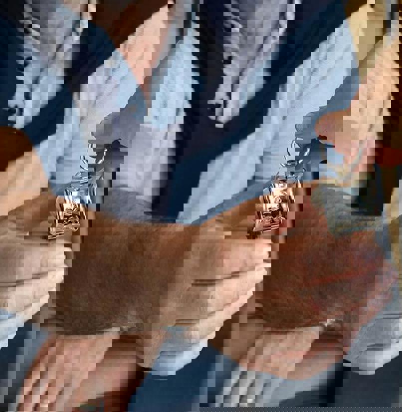 A woman's hand passing a set of keys to a man whose hand is stretched out to grab the keys