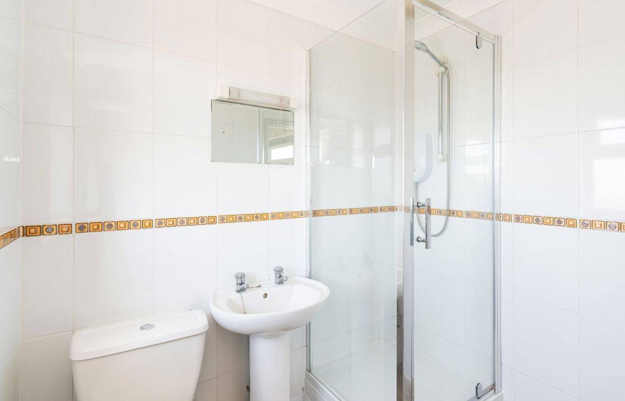 Internal of a Chesil Beach apartment bathroom with shower, sink and toilet