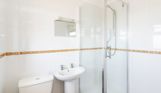 Internal of a Chesil Beach apartment bathroom with shower, sink and toilet